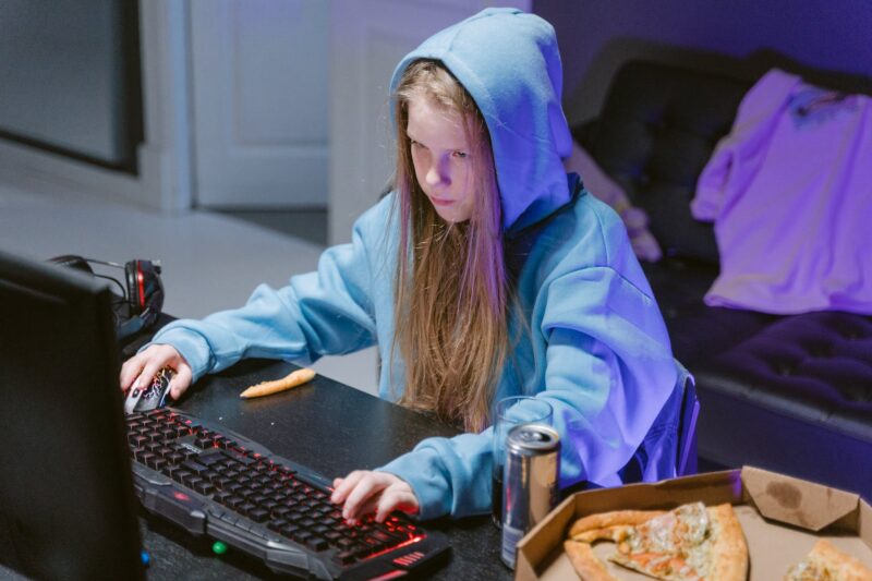 girl in blue hoodie playing a computer video game
